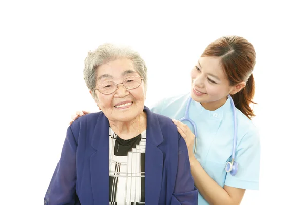 Sorridente medico asiatico e donna anziana — Foto Stock