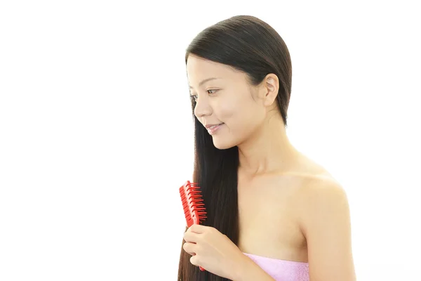 Vakker kvinne som børster håret – stockfoto