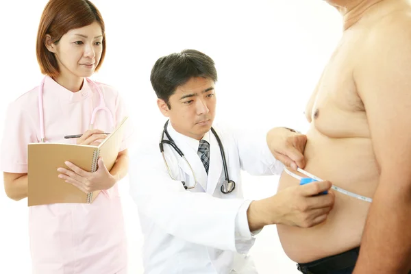 Läkare med en granskning av feta patienten — Stockfoto