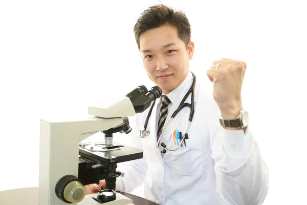 Arzt mit einer mikroskopischen Untersuchung — Stockfoto