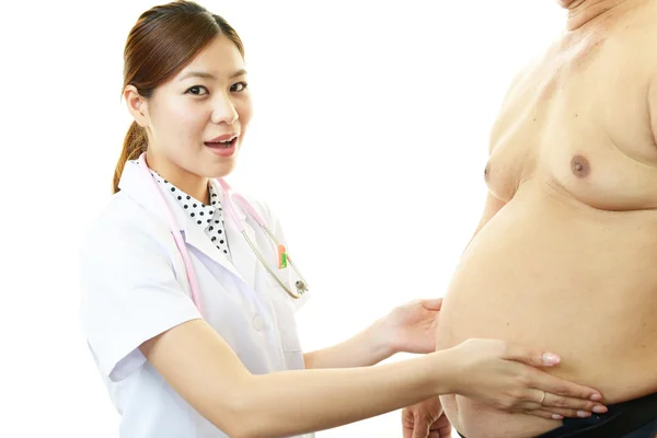 Médico serio examinando la obesidad de un paciente — Foto de Stock