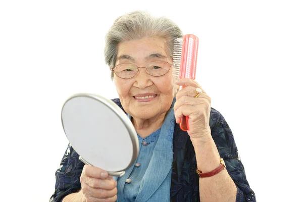 Vecchia donna pettinarsi i capelli — Foto Stock