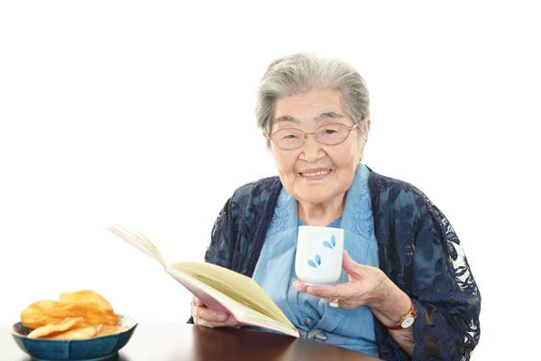 Mulher velha lendo seu livro — Fotografia de Stock