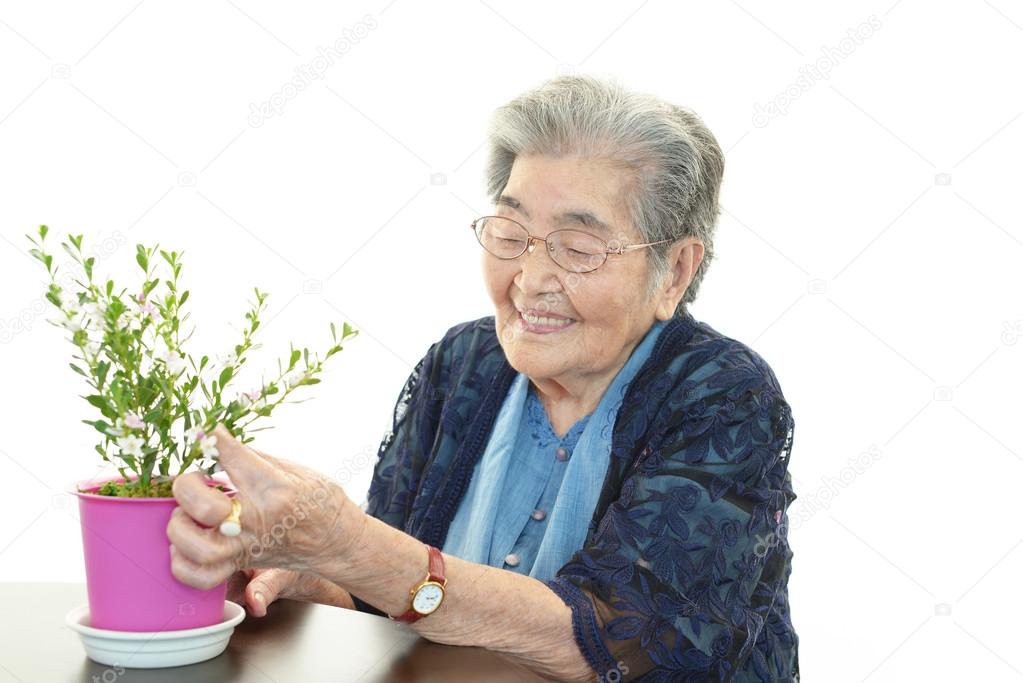 Smiling old woman with plant