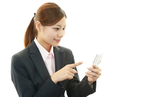 Woman smiling with a mobile phone — Stock Photo, Image