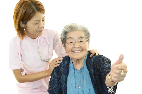 Amichevole infermiera si prende cura di una donna anziana — Foto Stock