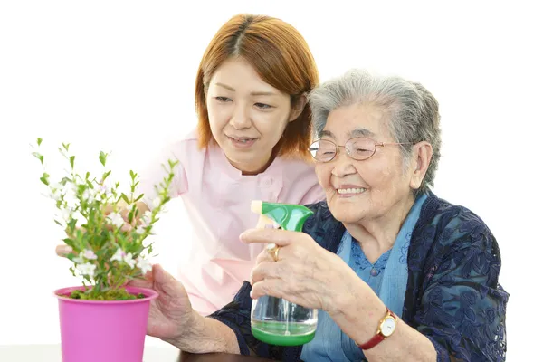 Freundliche Krankenschwester kümmert sich um eine ältere Frau Stockfoto