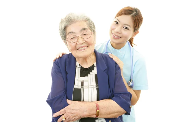 Souriant asiatique médecin et femme âgée — Photo