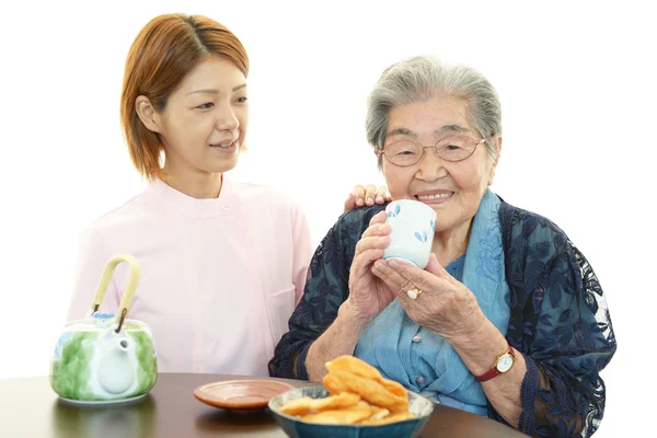 Donna anziana con il suo caregiver casa — Foto Stock