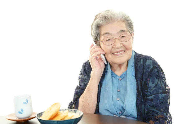 Oude vrouw met mobiele telefoon — Stockfoto