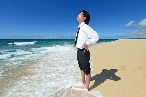 Jonge man op het strand genieten van zonlicht — Stockfoto