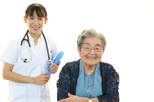 Smiling Asian medical staff with old woman — Stock Photo, Image