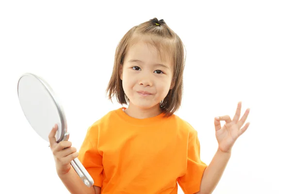 Маленькая девочка держит ручное зеркало — стоковое фото