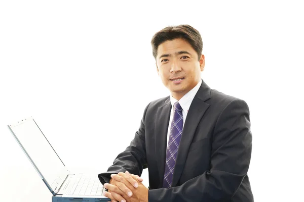 Smiling businessman using laptop — Stock Photo, Image