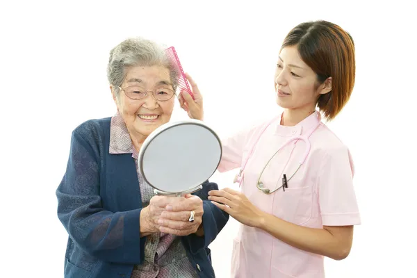 Amistosa enfermera cuida de una anciana —  Fotos de Stock