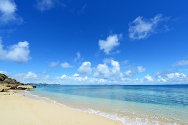 Yaz gökyüzü ve Okinawa 'nın güzel plajı