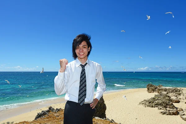 Молодой человек на пляже наслаждается солнечным светом — стоковое фото