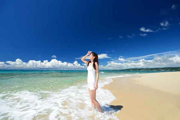 Jeune femme sur la plage profiter de la lumière du soleil — Photo