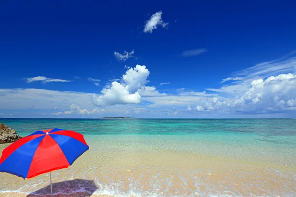 Het strand en het strand-paraplu van midzomer. — Stockfoto