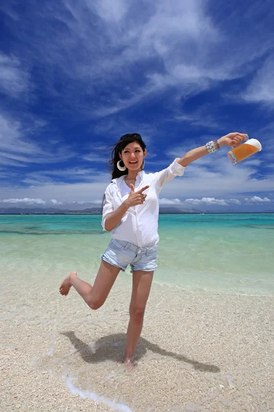 Mulher bebendo uma cerveja na praia — Fotografia de Stock