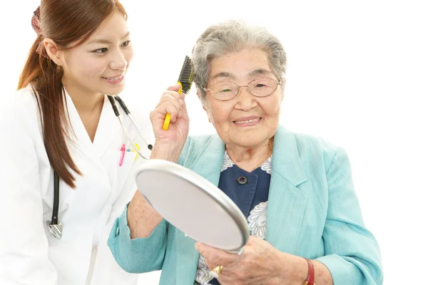 Souriant asiatique médecin et femme âgée — Photo