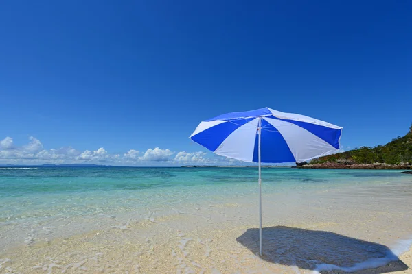 Het strand en het strand-paraplu van midzomer. — Stockfoto