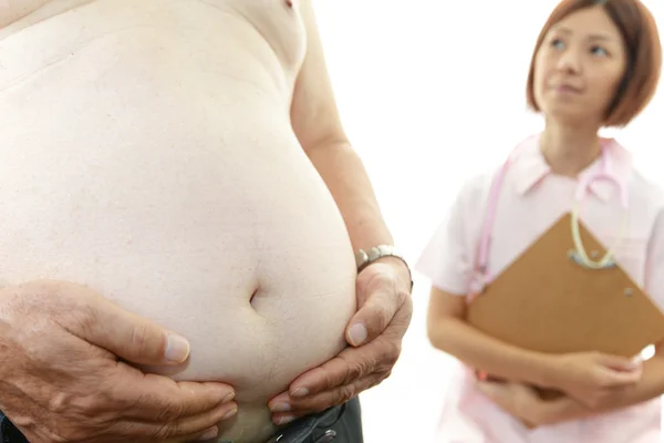 Médico serio examinando la obesidad de un paciente — Foto de Stock