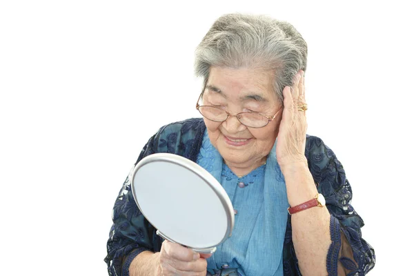 Old woman taking care of her hair — Stock Photo, Image