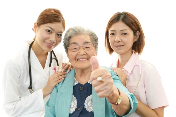 Zdravotnický personál se starší ženou — Stock fotografie