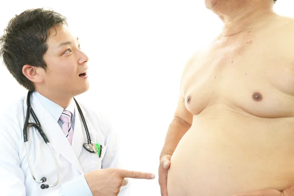 Médico serio examinando la obesidad de un paciente —  Fotos de Stock