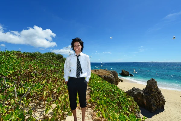 Молодой человек на пляже наслаждается солнечным светом — стоковое фото