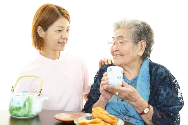 Friendly nurse cares for an elderly woman — Stock Photo, Image