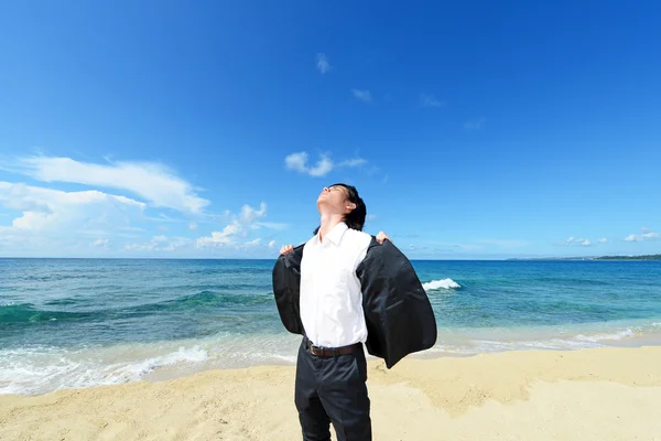 Jonge man op het strand genieten van zonlicht — Stockfoto