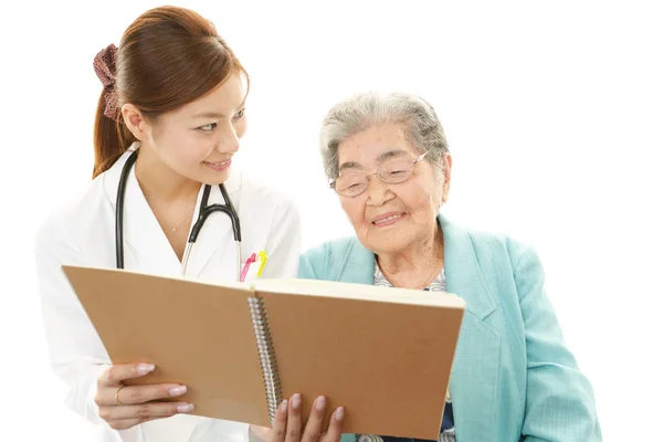 Souriant asiatique médecin et femme âgée — Photo