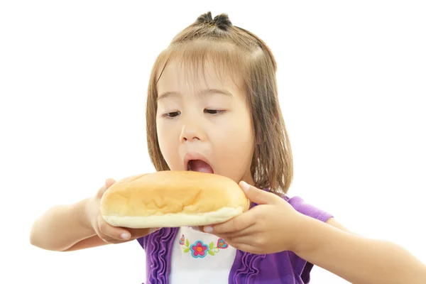 Маленькая девочка ест хлеб — стоковое фото