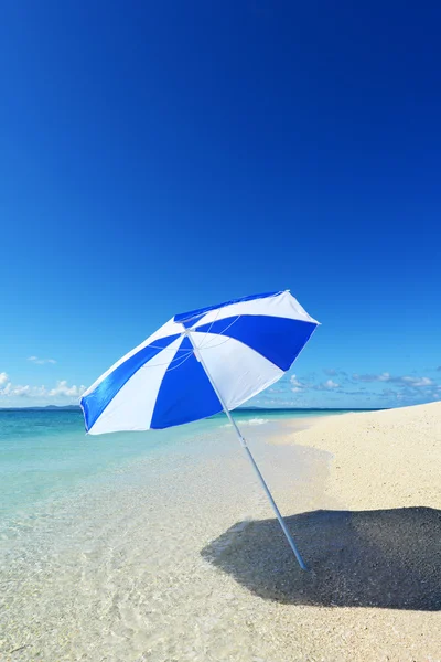 Der Strand und der Sonnenschirm im Hochsommer. — Stockfoto