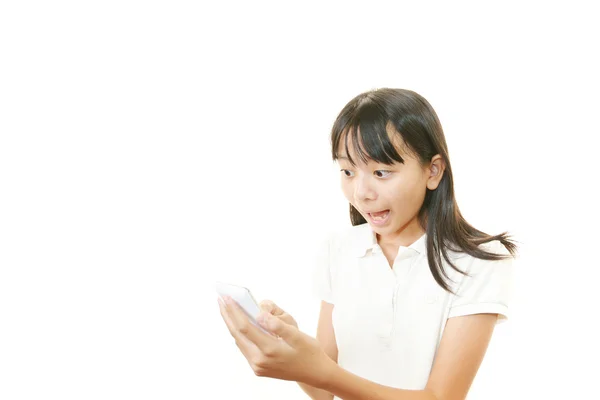 Chica sorprendida sosteniendo el teléfono móvil — Foto de Stock