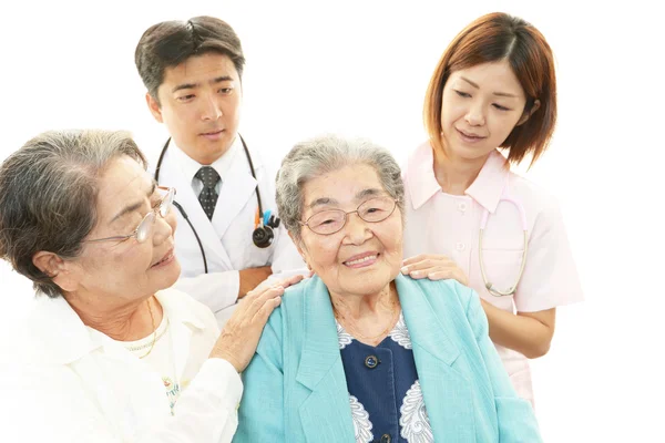 Leende asiatisk medicinsk personal med gamla kvinnor — Stockfoto