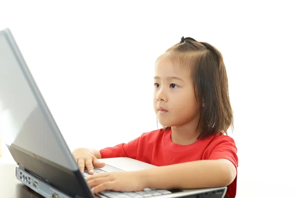 Χαριτωμένο κοριτσάκι χρησιμοποιώντας ένα φορητό υπολογιστή — Φωτογραφία Αρχείου