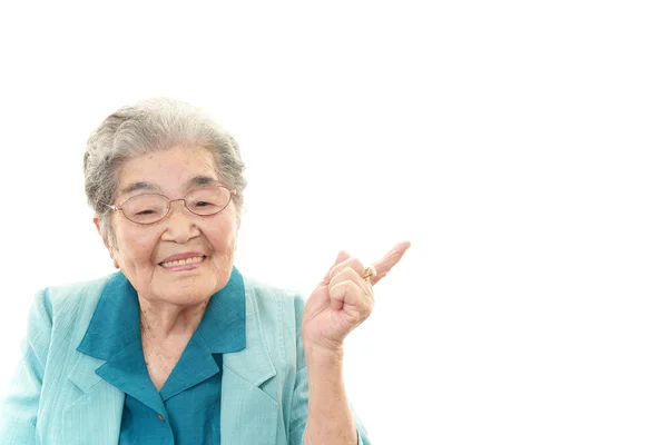 Happy old woman pointing. — Stock Photo, Image