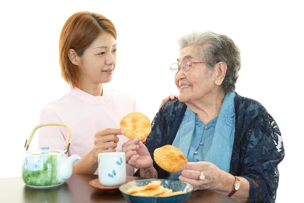 Freundliche Krankenschwester kümmert sich um eine ältere Frau — Stockfoto