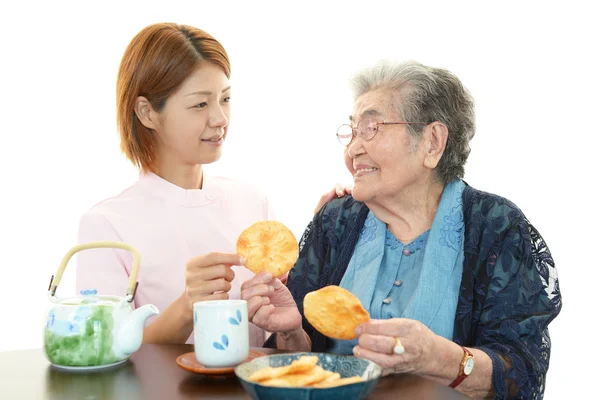Freundliche Krankenschwester kümmert sich um eine ältere Frau lizenzfreie Stockfotos