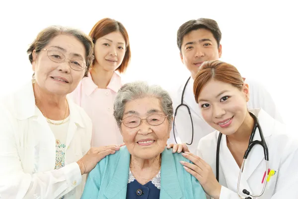 Lächelndes asiatisches medizinisches Personal mit alten Frauen — Stockfoto