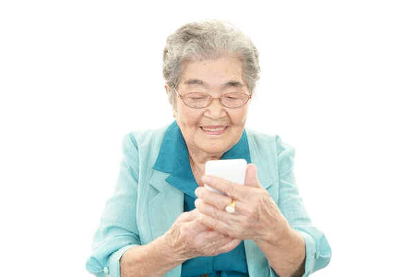 Lachende oude vrouw met mobiele telefoon — Stockfoto