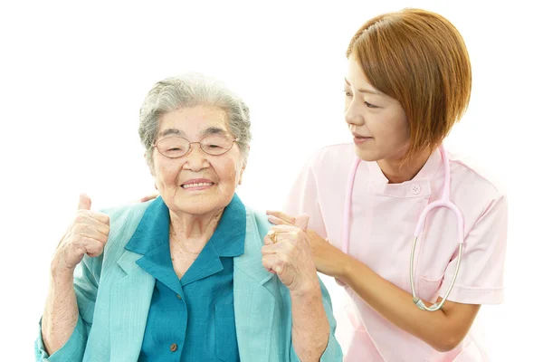 Freundliche Krankenschwester kümmert sich um eine ältere Frau — Stockfoto