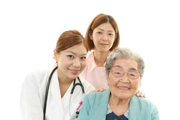 Sorrindo asiático equipe médica com mulher velha — Fotografia de Stock