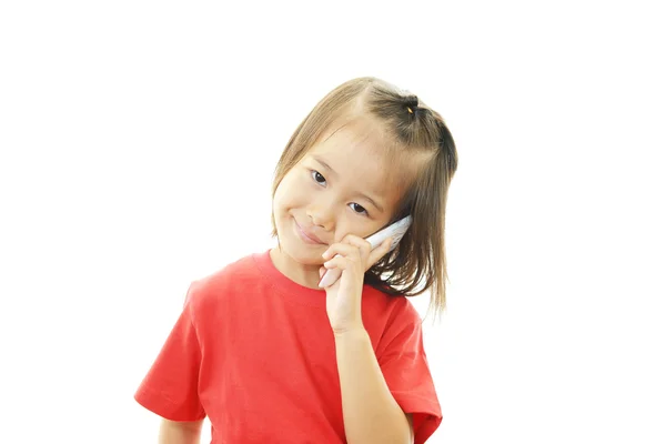 Šťastná holčička drží mobilní telefon a mluví — Stock fotografie