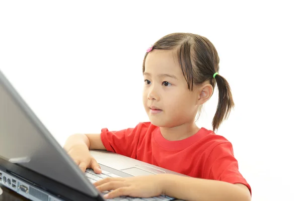 Schattig klein meisje met behulp van een laptop — Stockfoto