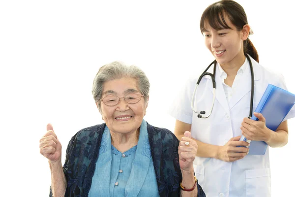 Usmívající se asijské lékař a starší žena — Stock fotografie