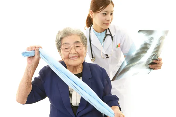 Medico asiatico e donna anziana — Foto Stock